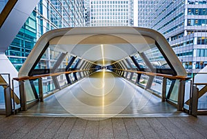 London, England - Pedestrian cross rail footbridge at the financial district of Canary Wharf with skyscrapers