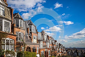 London, England - Traditional brick houses and flats on a nice summer morning with blue sky and clouds