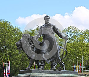 London, Great Britain -May 23, 2016: The Victoria Memorial, bronze figure a blacksmith with a hammer and a scroll