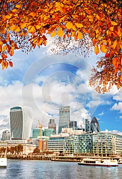 London with modern city against autumn leaves in England, UK