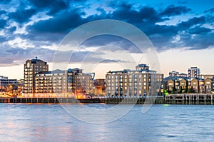 London old buildings near Canary Wharf at night. River reflections