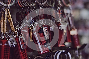 London red post box and red bus souvenir key chains on sale at a street market in London, UK.