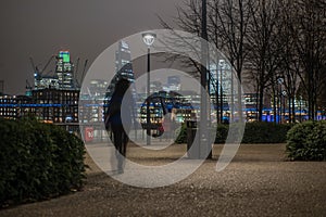 London skyline with an unrecognizable woman walking at night photo