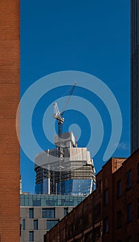 London skyscraper with crane under construction emerging between