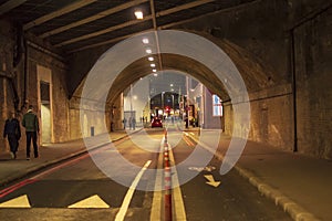 London tunnel with yellow lights with direction signs on the road