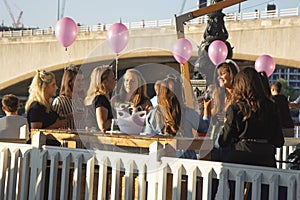 London, U.K. August 23, 2019 - Young people enjoy and relax at an outdoor cafe terrace in London, at river Thames. Wekeend time