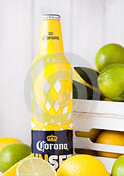 LONDON, UK - APRIL 27, 2018: Steel Bottle of Corona Extra Beer Sunset Editionon wooden background with fresh lemons and limes in w