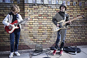 Teenagers play guitars during traditional Sunday lane flea market on Brick Lane