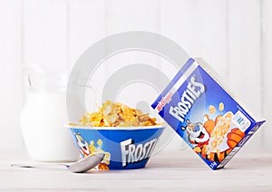LONDON, UK - JUNE 01, 2018: Box of Kellogg`s Frosties Breakfast Cereal with milk and plate on white wood.