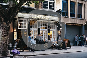 People drinking outside the College Arms pub in Bloomsbury, London, UK