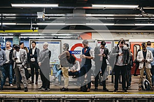 People on a platform of Moorgate station of London Underground, trains delayed, UK