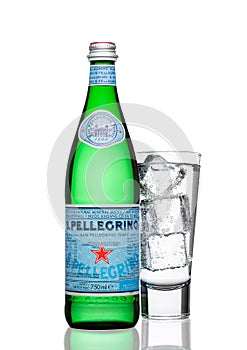 LONDON, UK - MARCH 30, 2017 : Bottle with glass of San Pellegrino mineral water on white. San Pellegrino is an Italian brand of mi