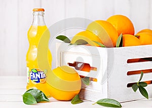 LONDON, UK - MARCH 31, 2018: Glass bottle of Fanta orange soft drink on white wooden background