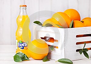 LONDON, UK - MARCH 31, 2018: Glass bottle of Fanta orange soft drink on white wooden background