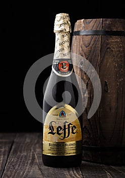 LONDON, UK - MAY 03, 2018: Cold bottle of Leffe beer next to wooden barrel on black background.Leffe is made by Abbaye de Leffe in