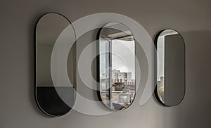 View of Three Capsula pill shaped mirror on white wall photo