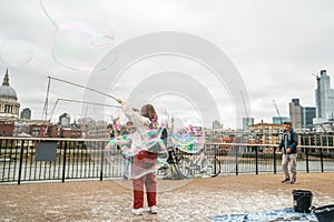 London, UK - October 2019: Giant soap bubbles show - street performers entertain tourists