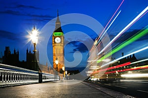 London, the UK. Red bus in motion and Big Ben at night