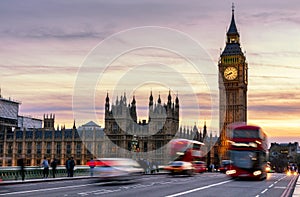 London, the UK. Red bus in motion and Big Ben, the Palace of Westminster. The icons of England