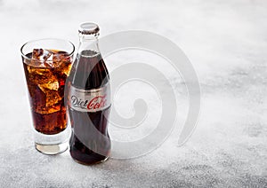 LONDON, UK - SEPTEMBER 28, 2018: Glass and bottle of Diet Coke Coca Cola soda drink with ice cubes and bubbles on stone kitchen ta