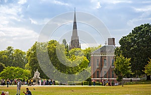 Kensington palace, queen Victoria monument in Hyde park view at sunny day with lots of people walking and resting in th, London UK