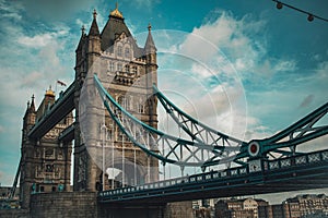 Tower Bridge in a dark blue sky with birds flying by and pedestrians and vehicles