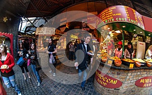 London, United Kingdom - March 31, 2007: Unknown shoppers eating street food while walking at Camden Lock, famous market