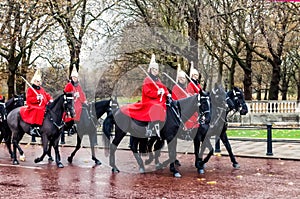 London, United Kingdom - 11/04/2016: Parade Royal Guard on black horses on street in London, after rain, in the background a bit b