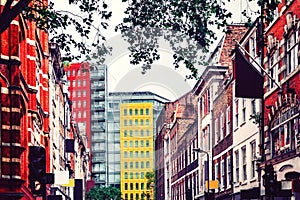 London. Yellow high apartment block surrounded by red brick traditional english houses.