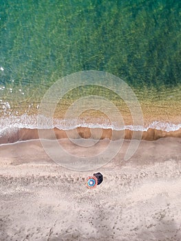 A lone beach umbrella on the sand beach, flat aerial view for background