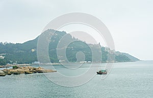 Lone boat in the sea and the mountain