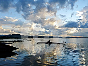 A lone boatman crossing beautiful Lak Lake, Central Vietnam at dusk