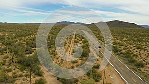 Lone car drives on Highway in Arizona through Sonoran Desert