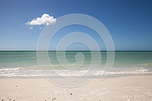 Lone cloud in a Blue sky over white sand of Tigertail Beach photo