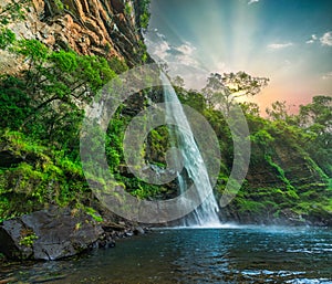 Lone creek waterfall and pond below during colorful sunset in Sabie