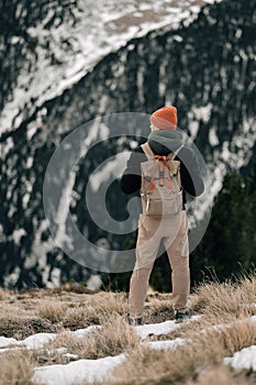 Lone Explorer Facing a Snow-Covered Mountain Range