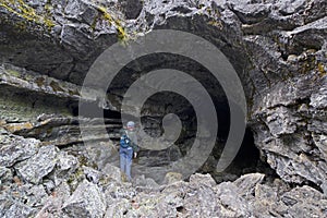 Lone Female Caver At Entrance To Large Cave
