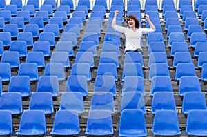 Lone female fan or spectator sitting cheering
