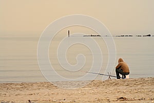 Lone fisherman on beach