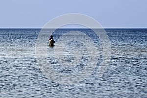 Lone fisherman fishing in the Baltic Sea.