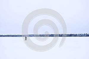 A lone fisherman on a frozen lake. Ice fishing