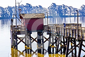 Lone Fisherman On Pier At Rivers Shoreline