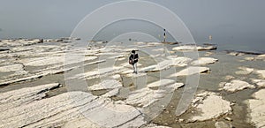 Lone guitarist playing on rocky landscape from above