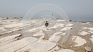 Lone guitarist playing on rocky landscape from above