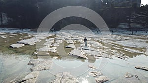 Lone guitarist playing on rocky landscape from above