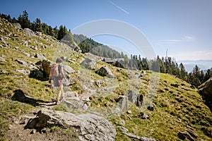 Lone hiker treks through a picturesque green mountainous landscape