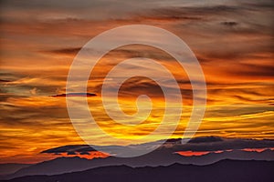 Lone lenticular cloud in a fiery sunset.