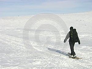 Lone man with a backpack snowshoeing