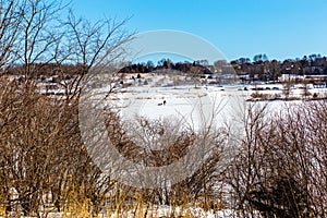 Lone man drilling for ice fishing on frozen lake