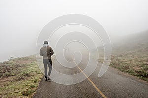 Lone man walking through the white fog